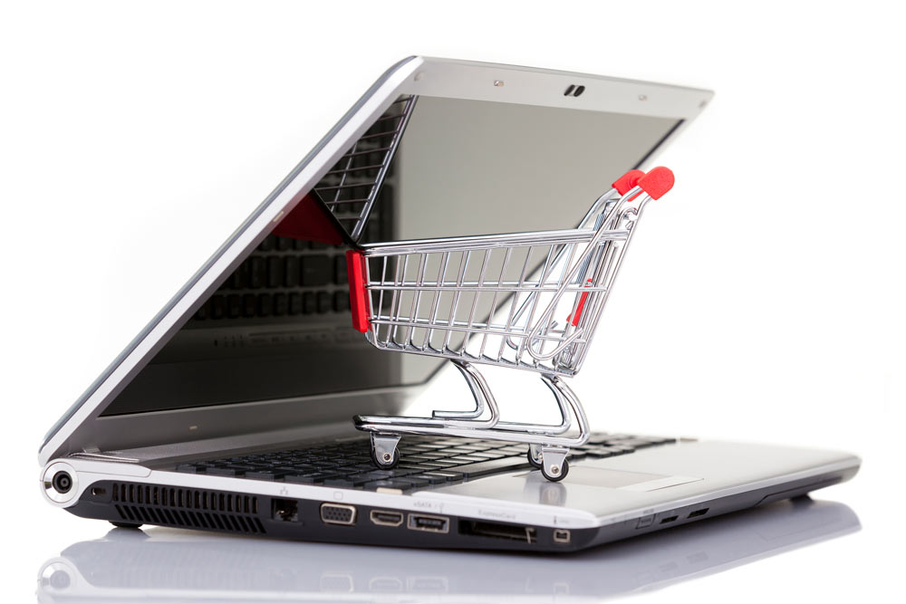Image of a mini shopping cart and a laptop